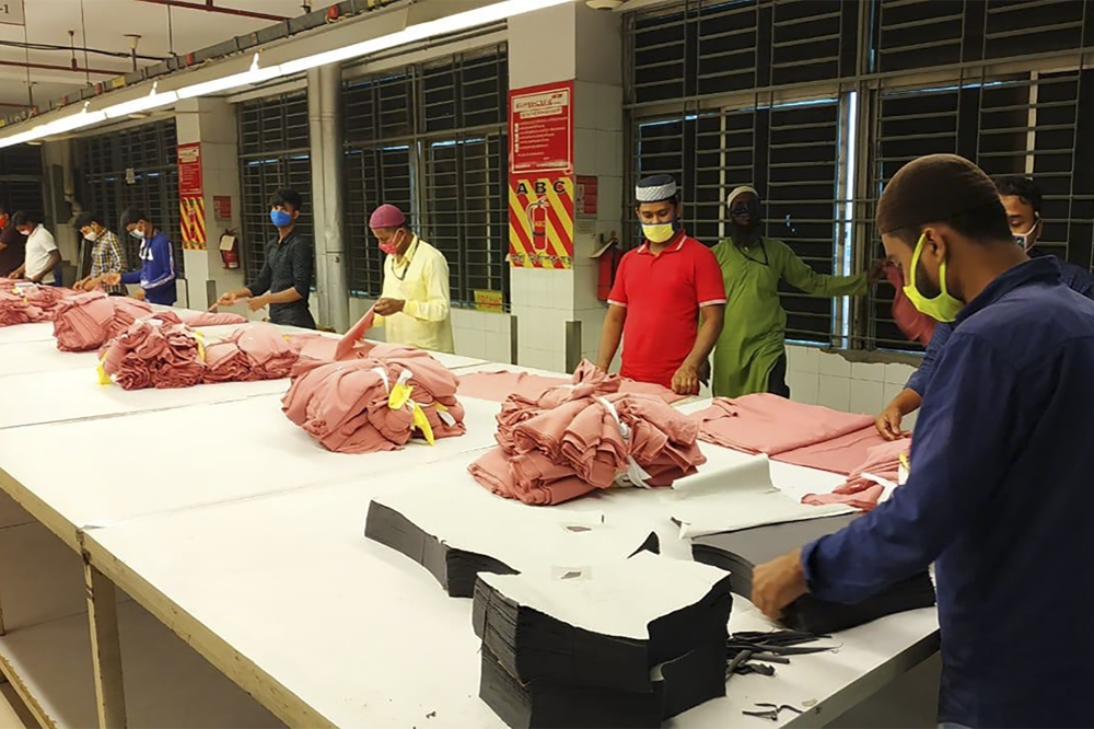 Labourers work in a garment factory during a nationwide coronavirus lockdown as a preventive measure against the COVID-19 coronavirus, in Asulia on April 26, 2020. AFP / STR