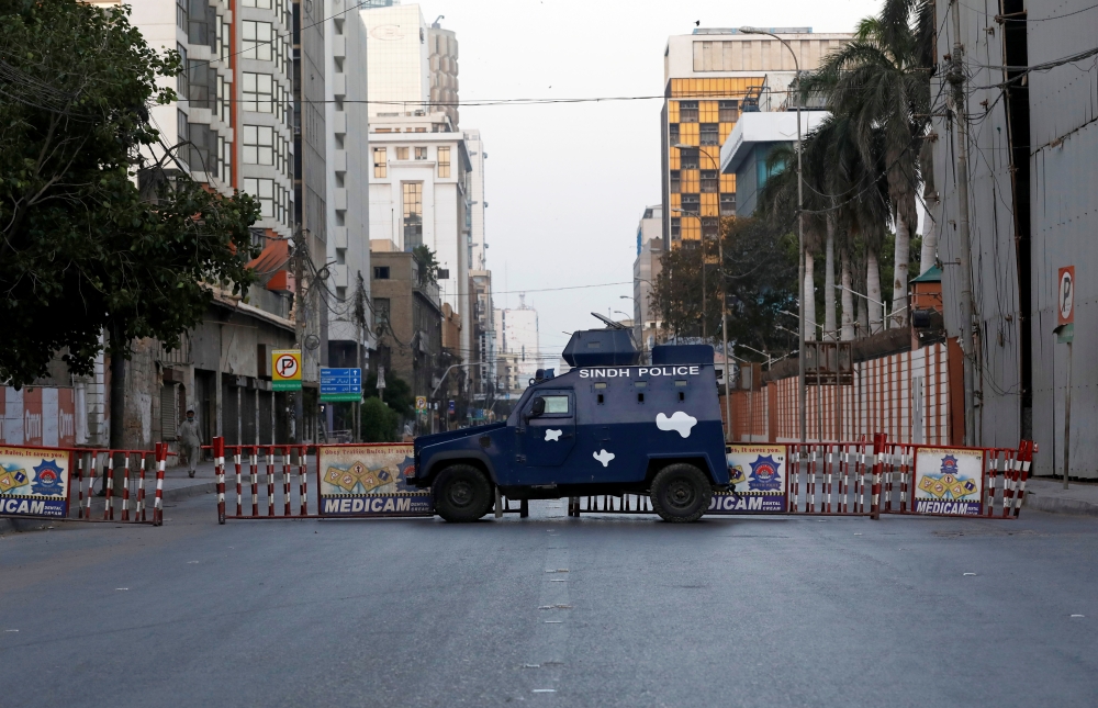 A police vehicle blocks a road in a business district during a lockdown in efforts to stem the spread of the coronavirus disease (COVID-19), as the Muslim fasting month of Ramadan begins in Karachi, Pakistan April 25, 2020. REUTERS/Akhtar Soomro
