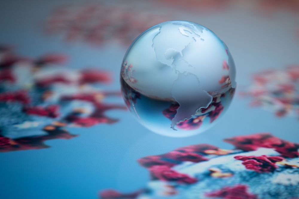 A globe showing the continents of North and South America is pictured on an illustration representation of COVID-19, the disease caused by the novel coronavirus in Paris on April 24, 2020. / AFP / JOEL SAGET