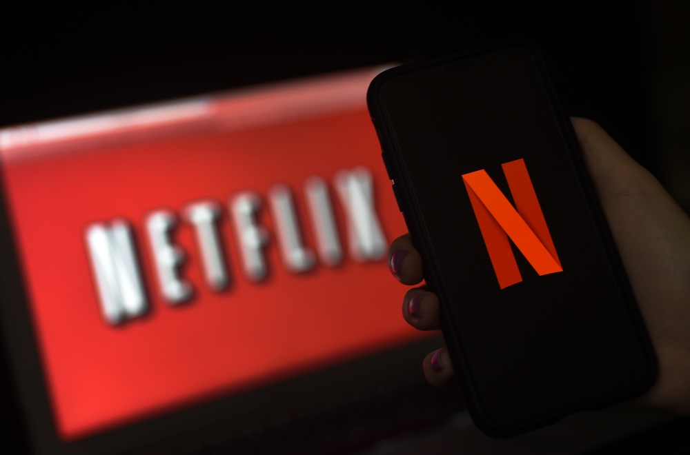 (FILES) In this file illustration photo taken on March 31, 2020 a computer screen and mobile phone display the Netflix logo in Arlington, Virginia. While coronavirus has brought Hollywood to a halt, Netflix has enjoyed record success. But will the streami