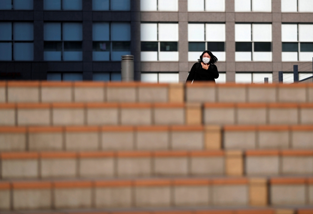 A woman wearing a protective face mask walks on a street during a Golden Week, a week-long holiday in Japan, under a nationwide state of emergency in Tokyo, Japan May 1, 2020, as the spread of the coronavirus disease (COVID-19) continues. REUTERS/Issei Ka