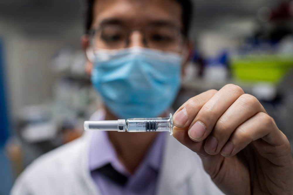 In this picture taken on April 29, 2020, an engineer shows an experimental vaccine for the COVID-19 coronavirus. AFP / NICOLAS ASFOURI 