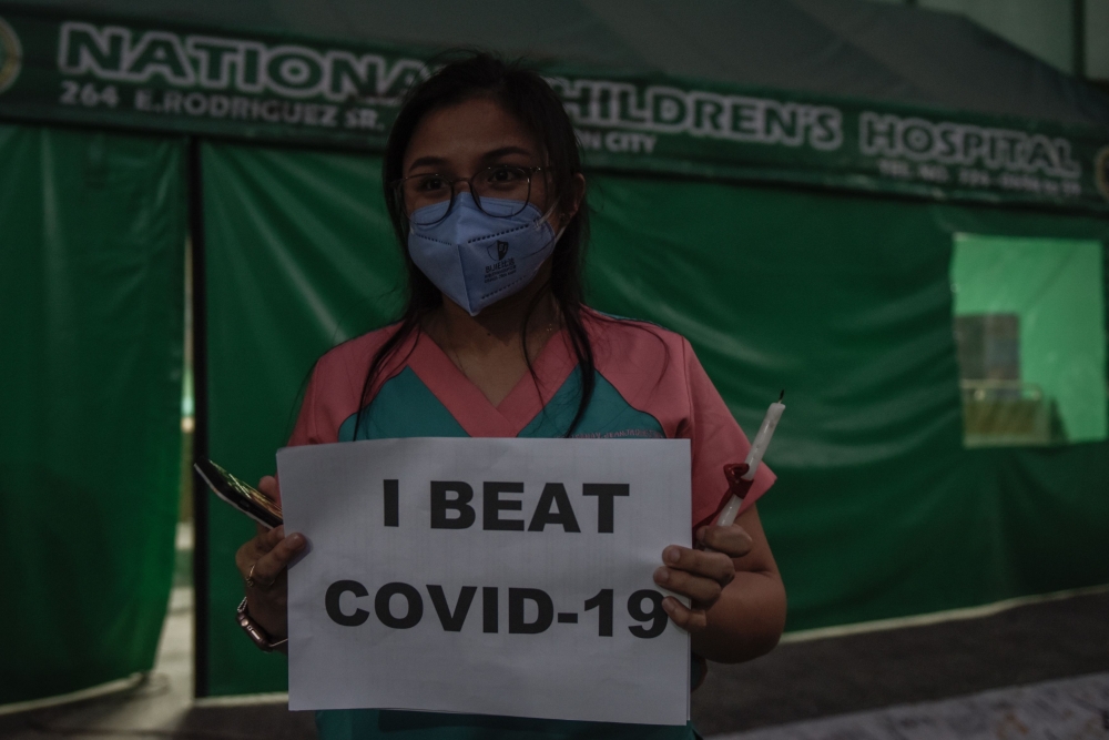 A medical staff member from the National Children's Hospital take part in a vigil to honour their fallen colleagues and call on the government to provide ample protection to frontline staff and the immediate release of their bonuses, in Quezon City on Apr