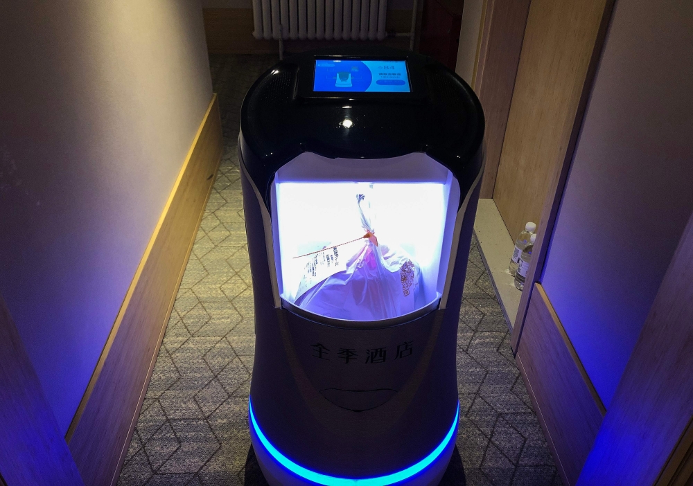 This photo taken on April 28, 2020 shows a robot capable of taking elevators and navigating hallways on its own delivering food to a guest at a quarantine hotel housing people from Hubei province in Beijing. AFP / Jing Xuan Teng