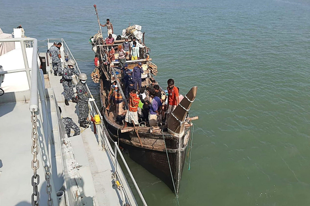 In this picture taken on May 2, 2020, Rohingya refugees stranded at sea are seen on a boat near the coast of Cox's Bazar. Dozens of Rohingya refugees believed to have come from two boats stranded at sea for weeks as they tried to reach Malaysia landed on 