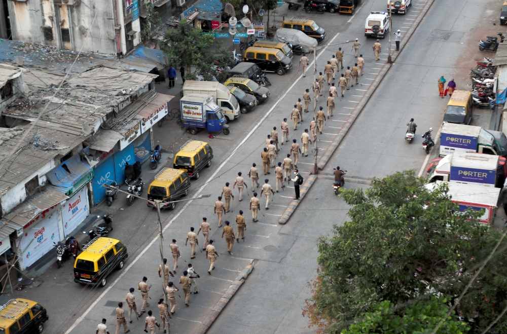 Police officers march on a street in Dharavi, one of Asia's largest slums, after the extension of the lockdown in Maharashtra state, to control the spread of coronavirus disease (COVID-19), in Mumbai, India, April 11, 2020. REUTERS/Francis Mascarenhas/Fil