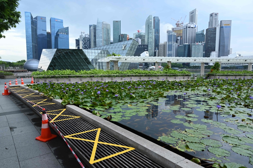 Tape is used to mark off spaces for social distancing at a seating area, as a preventive measure against the spread of the COVID-19 novel coronavirus, along the promenade at Marina Bay in Singapore on May 4, 2020. / AFP / Roslan RAHMAN