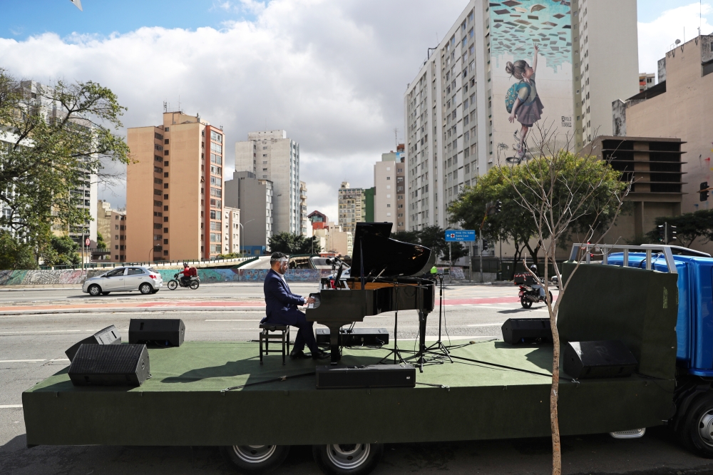 Pianist Rodrigo Cunha serenades from an open truck the lonely mothers in quarantine as the spread of the coronavirus disease (COVID-19) continues in Sao Paulo, Brazil, May 8, 2020. Picture taken May 8, 2020. REUTERS/Amanda Perobelli