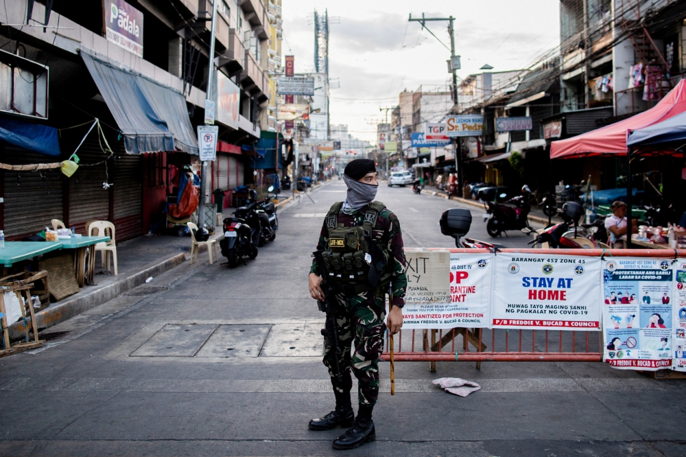 FILE PHOTO: A soldier wearing a face mask holds on his weapon as he guards an empty street following the lockdown imposed to contain the coronavirus disease (COVID-19) in Manila, Philippines, April 24, 2020. REUTERS/Eloisa Lopez/File Photo
