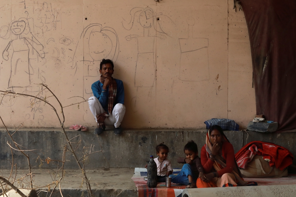 Migrants are sit outside a shelter home, during an extended nationwide lockdown to slow the spread of the coronavirus disease (COVID-19), in New Delhi, India, May 14, 2020. Reuters/Anushree Fadnavis