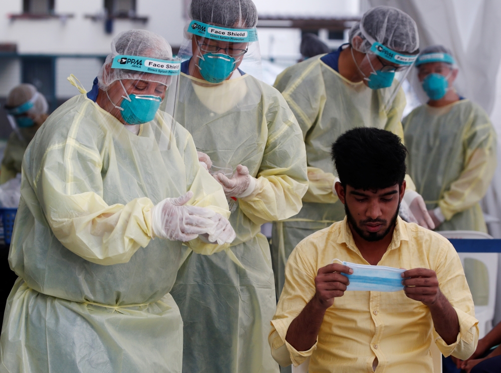 :Medical workers prepare to perform a nose swab on a migrant worker at a dormitory, amid the coronavirus disease (COVID-19) outbreak in Singapore May 15, 2020. REUTERS/Edgar Su
