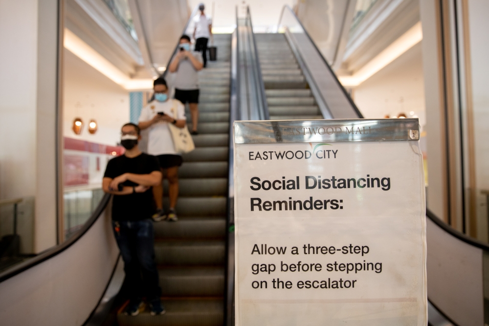 A poster reminding shoppers to maintain social distance to prevent the spread of the coronavirus disease (COVID-19) is placed beside an escalator in a shopping mall in Quezon City, Metro Manila, Philippines, May 17, 2020. REUTERS/Eloisa Lopez
