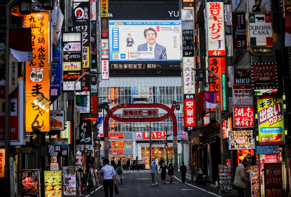 A large screen on a building shows live broadcasting of Japan's Prime Minister Shinzo Abe's news conference on Japan's response to the coronavirus disease (COVID-19) at Kabukicho entertainment district in Tokyo, Japan May 14, 2020. REUTERS/Issei Kato
