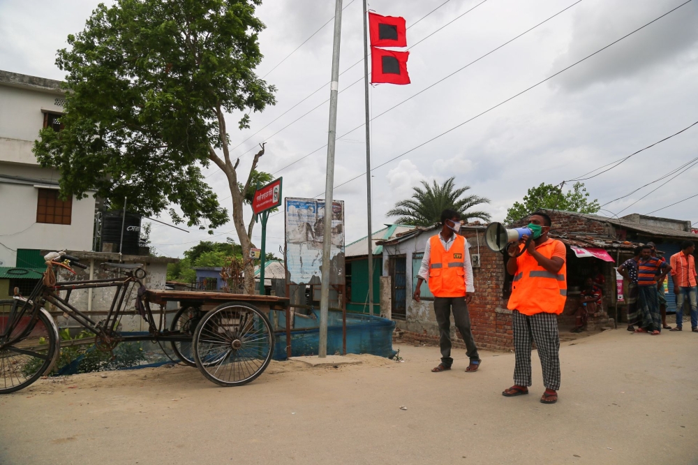 :A Cyclone Preparedness Programme (CPP) volunteer uses a megaphone to urge residents to evacuate to shelters ahead of the expected landfall of cyclone Amphan in Khulna on May 19, 2020. India and Bangladesh began evacuating more than two million people May