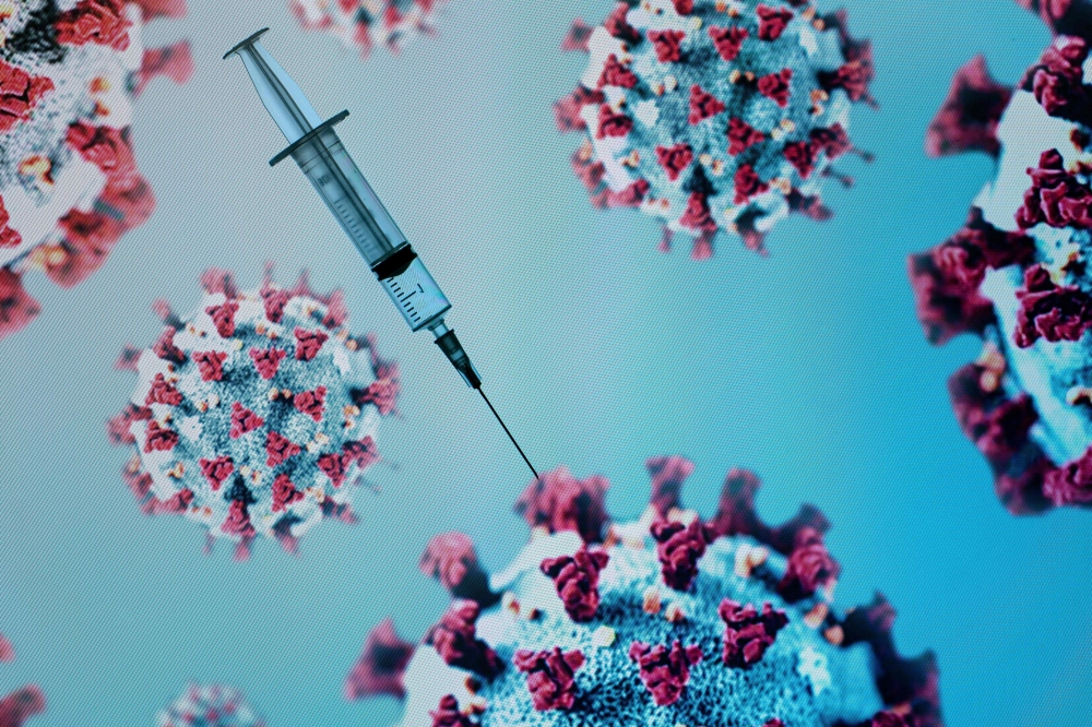 A syringe is pictured on an illustration representation of COVID-19, the disease caused by the novel coronavirus in Paris on May 18, 2020. / AFP / JOEL SAGET

