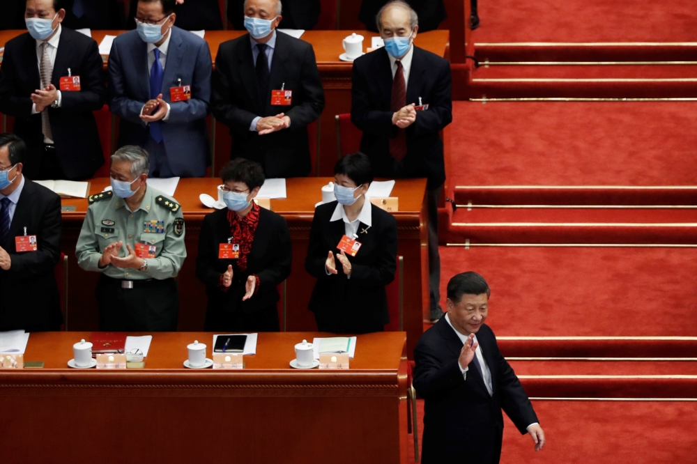 Chinese President Xi Jinping greets officials wearing face masks following the coronavirus disease (COVID-19) outbreak as he arrives for the opening session of the Chinese People's Political Consultative Conference (CPPCC) at the Great Hall of the People 