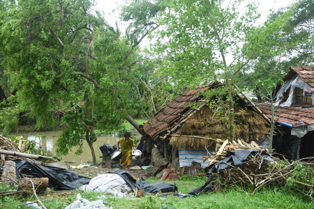 A woman salvages items from her house damaged by cyclone Amphan in Midnapore, West Bengal, on May 21, 2020.  / AFP / Dibyangshu SARKAR
