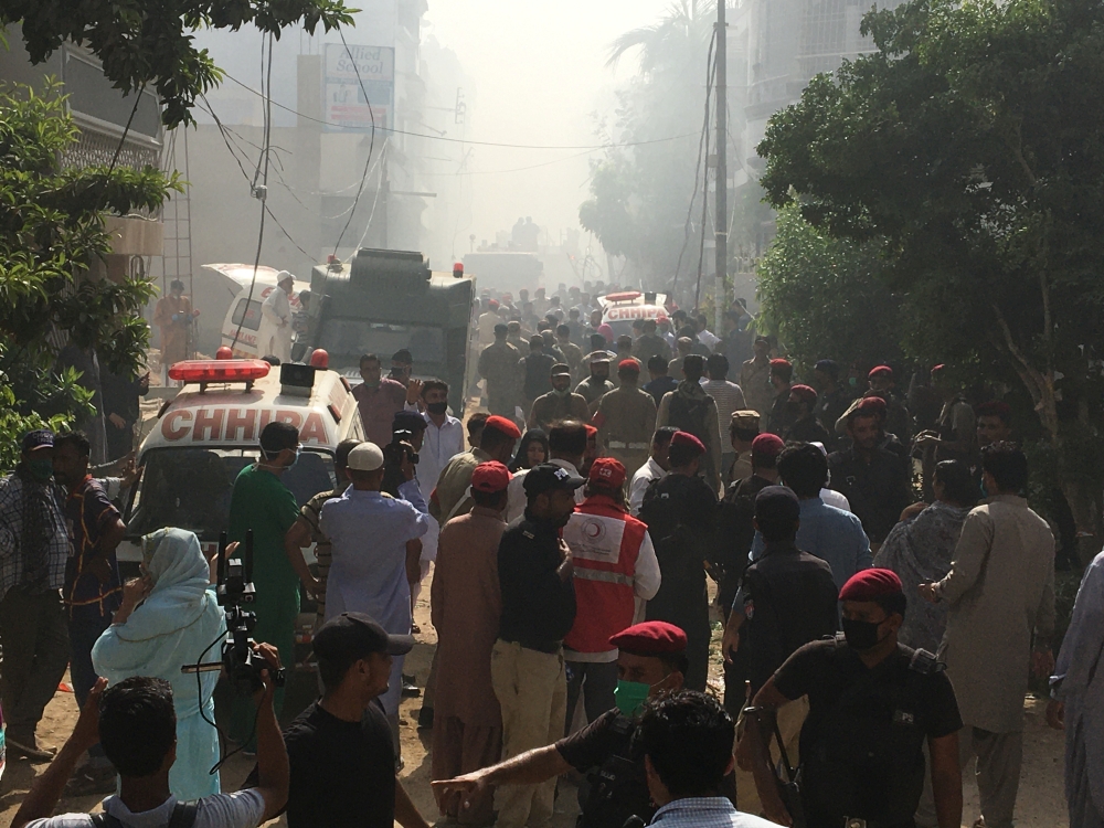 Ambulances and fire brigade vehicles gather at the site of a passenger plane crash in a residential area near an airport in Karachi, Pakistan May 22, 2020. REUTERS/Akhtar Soomro

