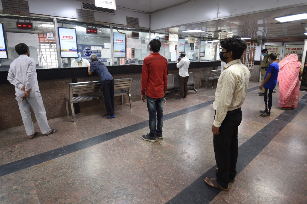 People queue at a railway reservation counter after the government eased restrictions imposed as a preventive measure against the spread of the COVID-19 Coronavirus in New Delhi on May 22, 2020. / AFP / Money Sharma 