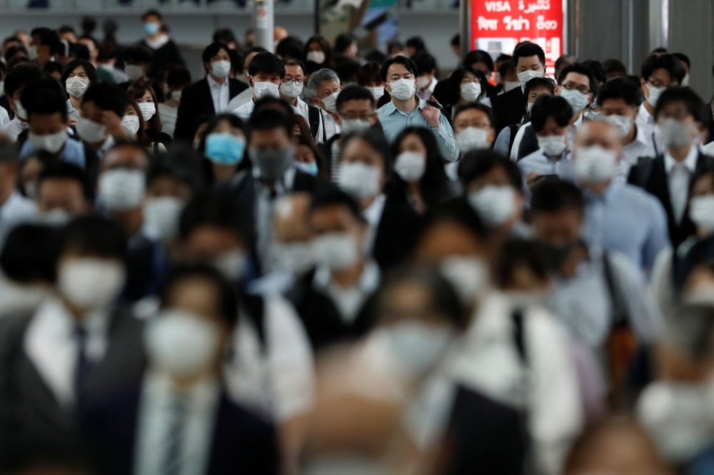 People wearing protective masks make their way during rush hour at Shinagawa station on the first day after the Japanese government lifted the state of emergency in Tokyo, Japan, May 26, 2020.REUTERS/Kim Kyung-Hoon
