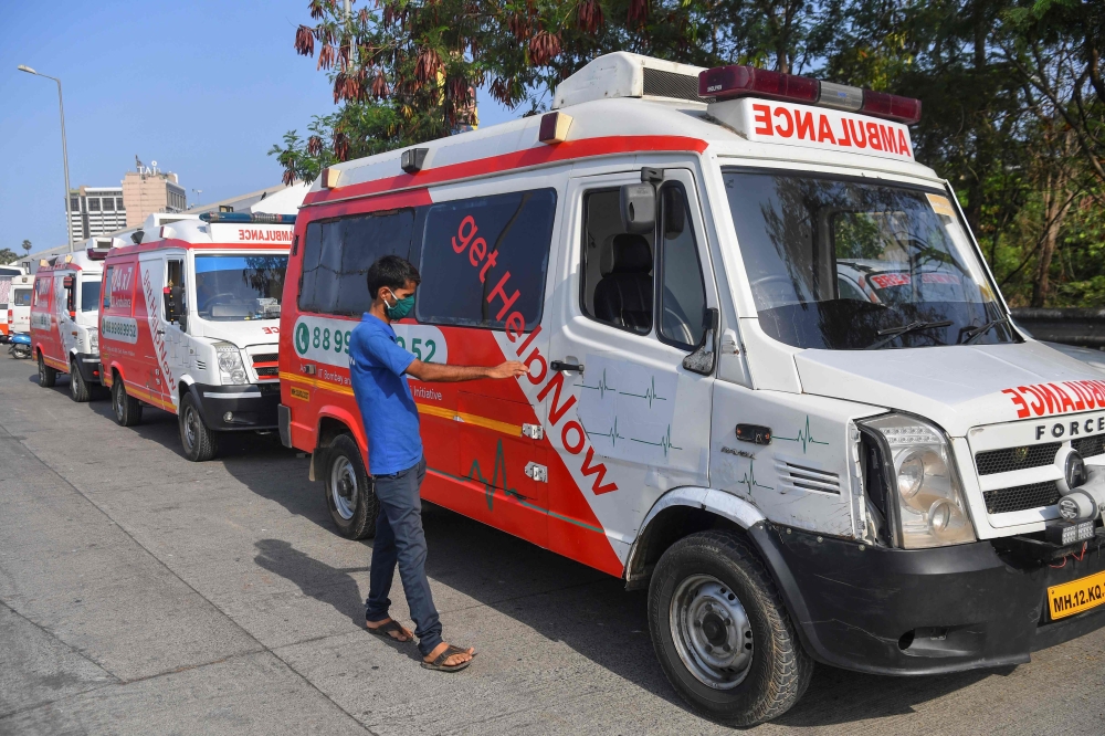 In this photograph taken on May 24, 2020, ambulance driver Alam Shaikh from HelpNow gets into his vehicle at a parking station, after the government eased a nationwide lockdown imposed as a preventive measure against the COVID-19 coronavirus, in Mumbai. A