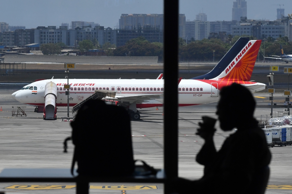 A passengers sips a drink in the food court of the Chhatrapati Shivaji Maharaj International Airport (CSMIA) before boarding a plane after domestic flights resumed, in Mumbai on May 28, 2020. AFP / Indranil Mukherjee 
