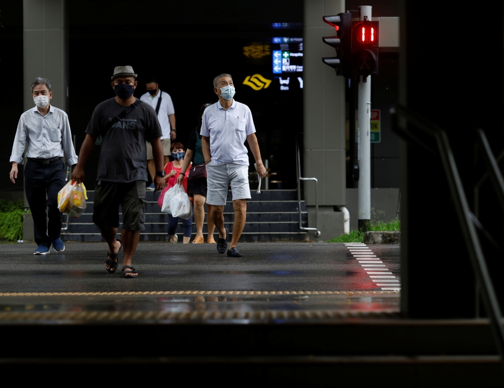 People wearing face masks cross a street amid the coronavirus disease (COVID-19) outbreak in Singapore on June 1, 2020. REUTERS/Edgar Su
