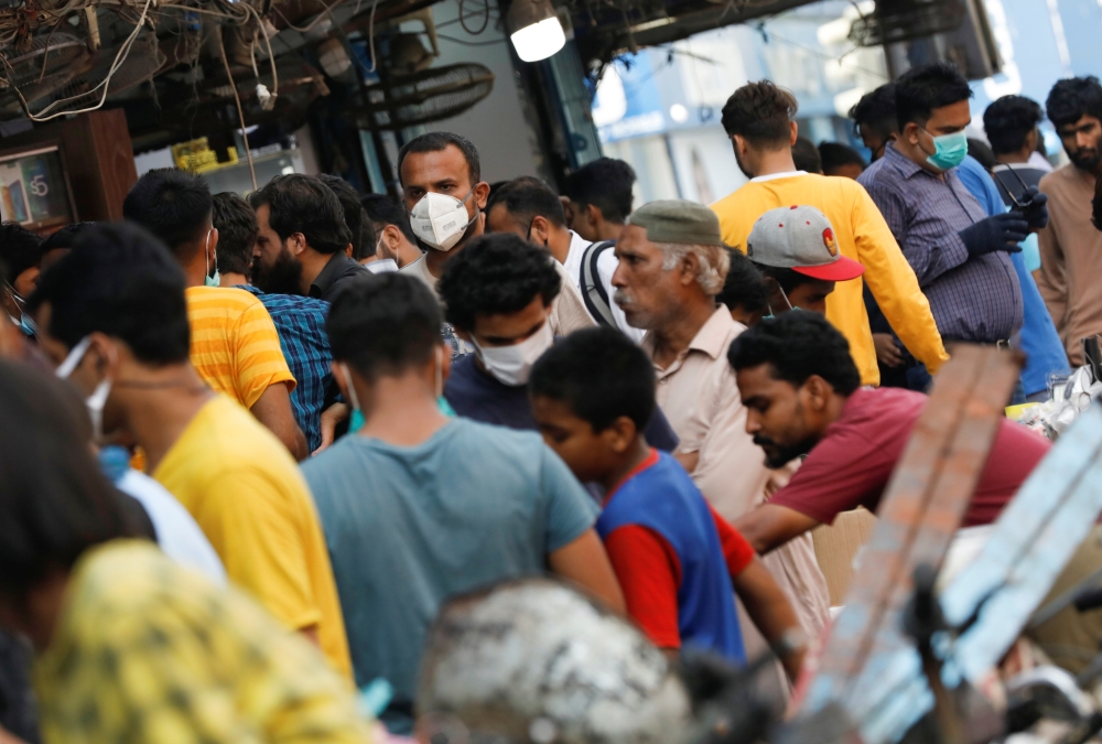 A man wearing a protective face mask walks amidst the rush of people outside an electronics market, after Pakistan started easing the lockdown restrictions, as the outbreak of the coronavirus disease (COVID-19) continues, in Karachi, Pakistan June 4, 2020