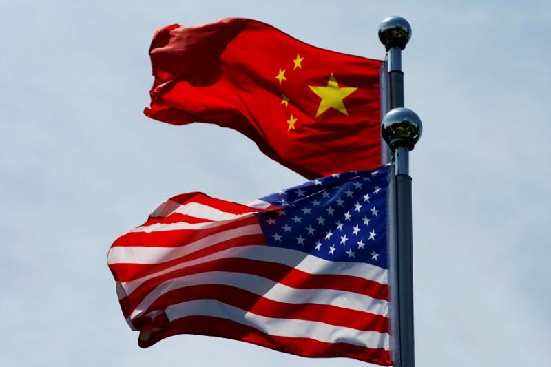 FILE PHOTO: Chinese and U.S. flags flutter near The Bund in Shanghai, China July 30, 2019. REUTERS/Aly Song/File Photo
