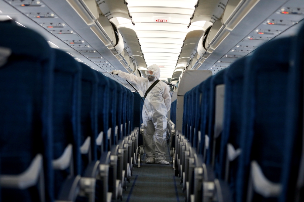A health worker sprays disinfectant inside a Vietnam Airlines airplane to protect from the recent coronavirus outbreak, at Noi Bai airport in Hanoi, Vietnam February 21, 2020. REUTERS/Kham - RC2U4F9KDLO4/File Photo
