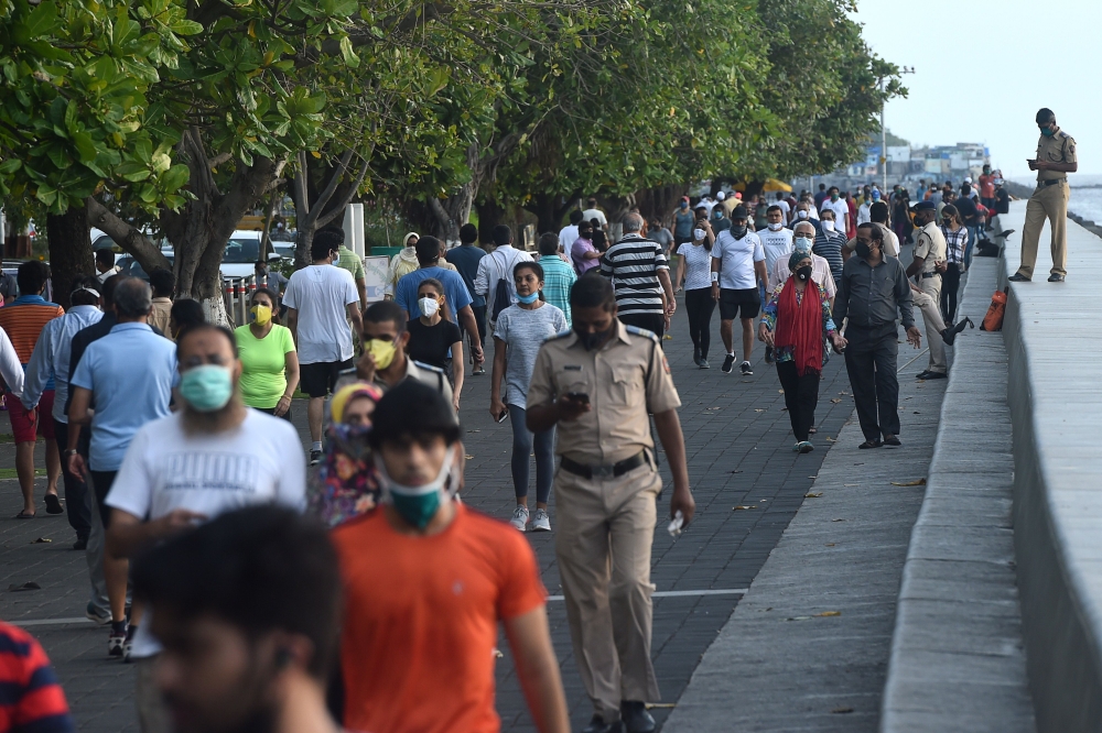 People walk at the sea front after the government eased a lockdown imposed as a preventive measure against the COVID-19 coronavirus, in Mumbai on June 8, 2020.  AFP / Punit PARANJPE
