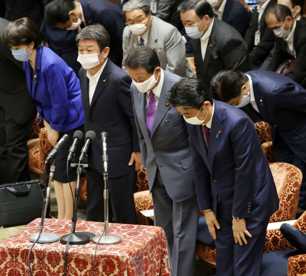 Japan's Prime Minister Shinzo Abe (R) and Finance Minister Taro Aso (2nd R) wearing face masks amid concerns over the spread of coronavirus (COVID-19) bow during a budget committee session in the lower house at parliament in Tokyo on June 10, 2020. AFP / 