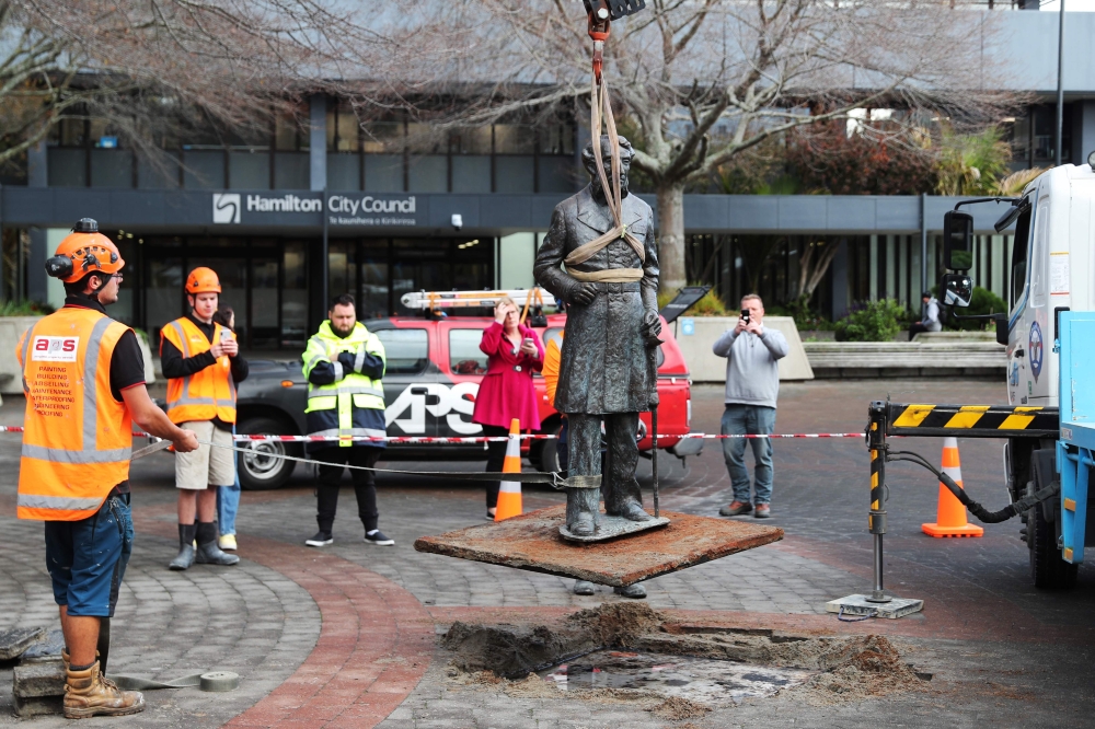 Workers remove a controversial statue of Captain John Fane Charles Hamilton from Civic Square in Hamilton on June 12, 2020, / AFP / MICHAEL BRADLEY