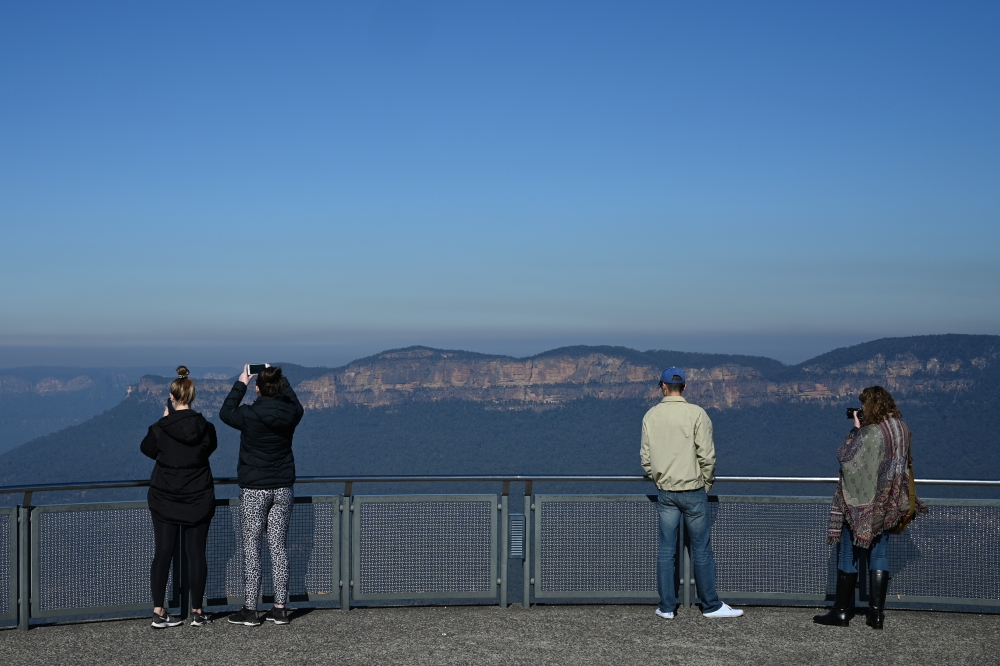 Tourists take in the view at a Three Sisters rock formation lookout in Blue Mountains National Park in the wake of regional travel re-opening as the coronavirus disease (COVID-19) restrictions are eased in New South Wales, in Katoomba, Australia, June 5, 