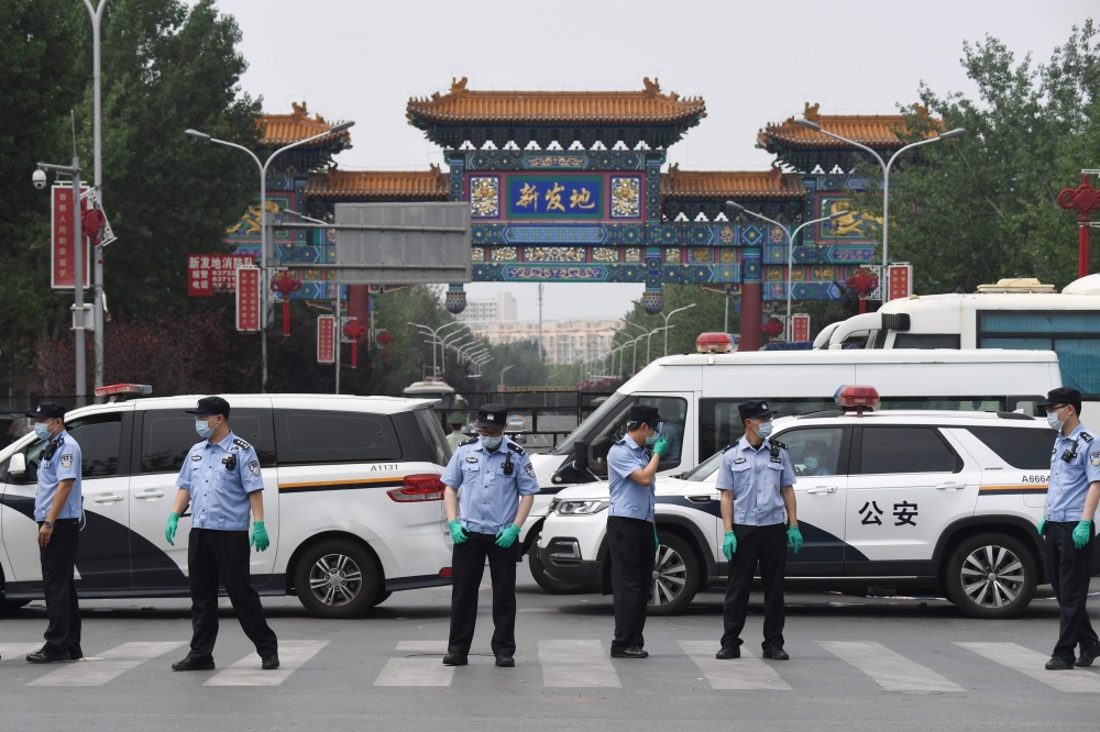 TOPSHOT - Chinese police guard the entrance to the closed Xinfadi market in Beijing on June 13, 2020. Eleven residential estates in south Beijing have been locked down due to a fresh cluster of coronavirus cases linked to the Xinfadi meat market, official
