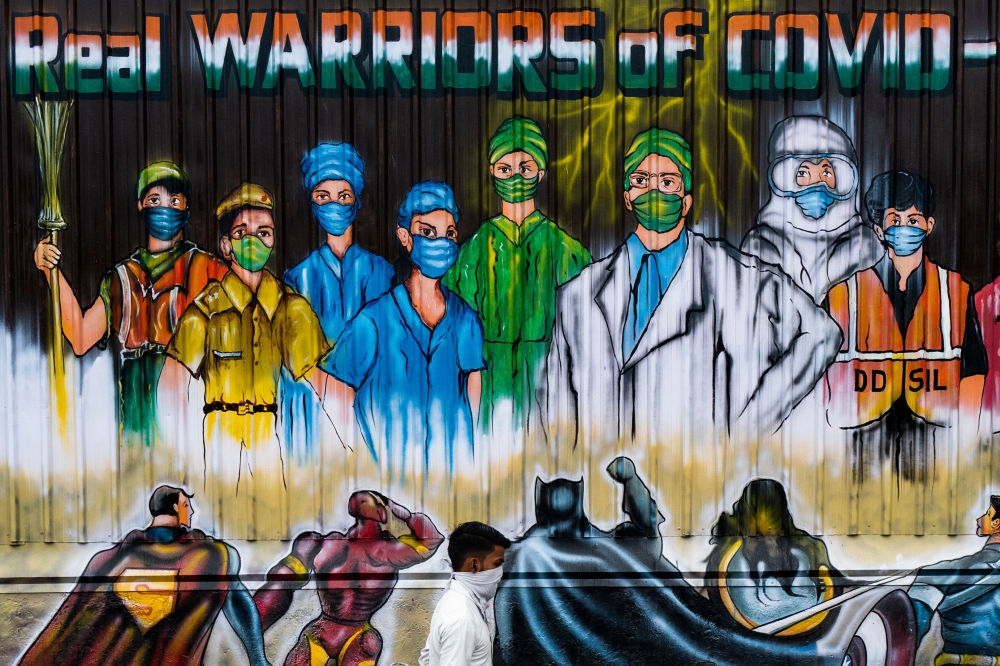 A man walks past a mural painted on a garbage dump after the government eased a nationwide lockdown imposed as a preventive measure against the COVID-19 coronavirus in New Delhi on June 13, 2020. AFP / Jewel Samad 