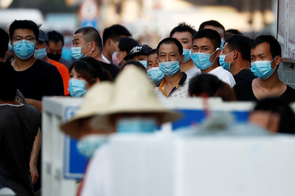 People are wearing face masks inside the Jingshen seafood market which has been closed for business after new coronavirus infections were detected, in Beijing, China, June 12, 2020. REUTERS/Thomas Peter
