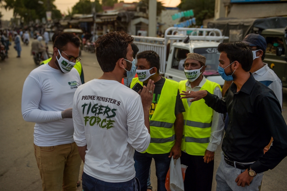 Members of Prime Minister Imran Khan's Corona Relief Tiger Force volunteers gather before starting a COVID-19 coronavirus awareness campaign at Raja bazar in Rawalpindi on June 10, 2020.  / AFP / Farooq NAEEM
