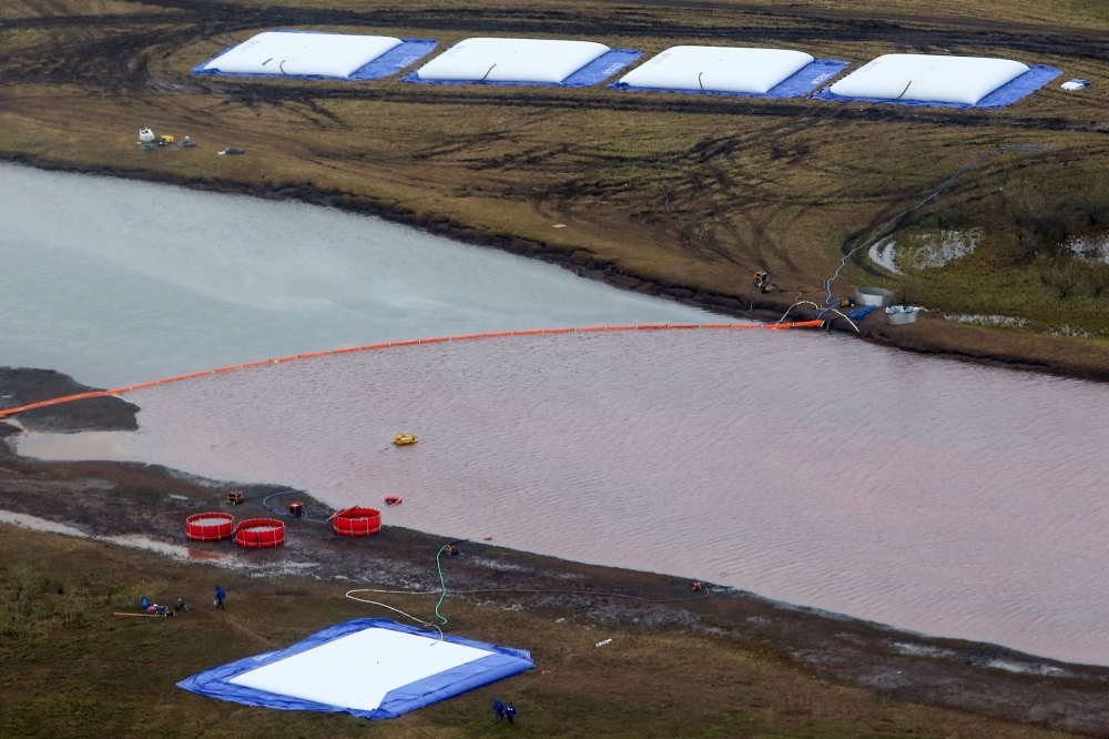 Employees of Russia's state-owned oil pipeline monopoly Transneft take part in a clean-up operation following a massive fuel spill in the Ambarnaya River outside Norilsk on June 10, 2020. AFP / Irina YARINSKAYA