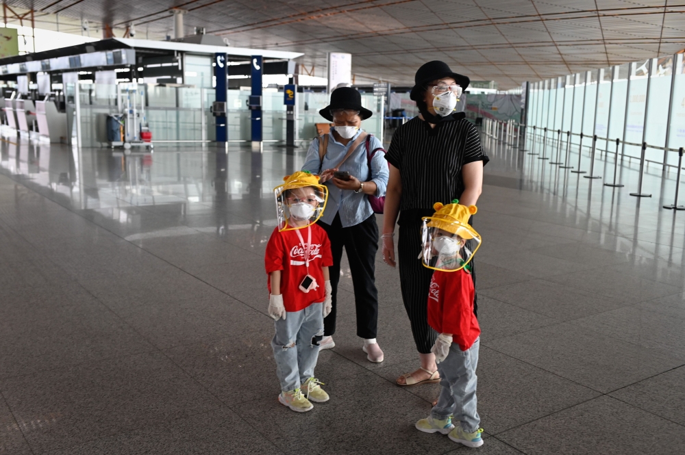 People wearing protective gear are pictured inside the terminal at Beijing's international airport on June 17, 2020. AFP / STR
