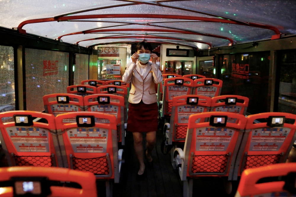 A tour guide adjust her face mask to protect herself from the coronavirus disease (COVID-19) in an empty Taipei Sightseeing bus in Taipei, Taiwan, May 22, 2020. REUTERS/Ann Wang/File Photo