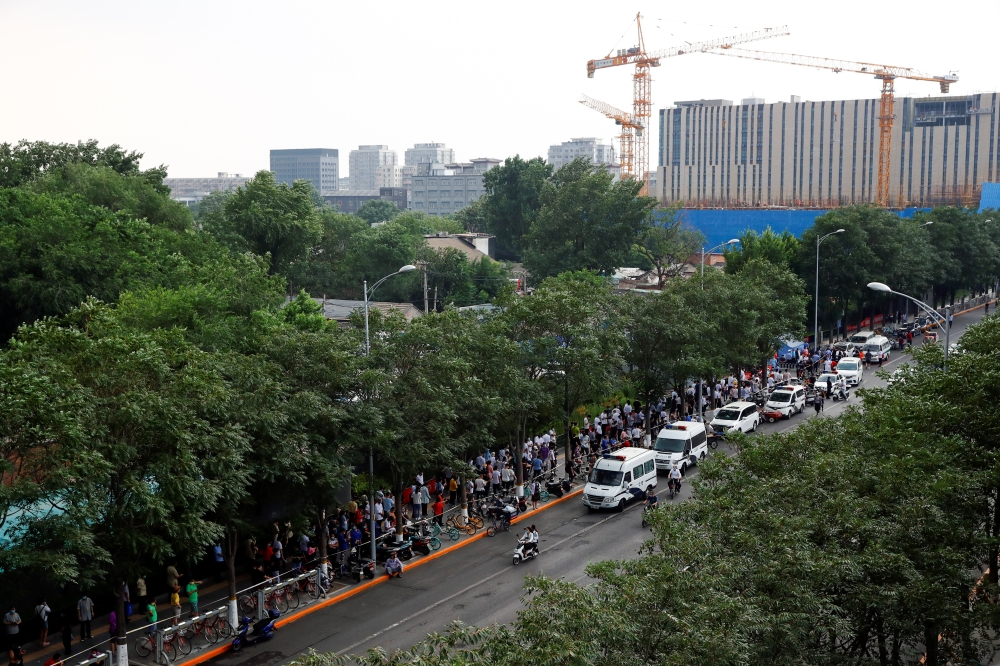 People line up to go into a makeshift testing center to receive nucleic acid tests after a new outbreak of the coronavirus disease (COVID-19) in Beijing, China, June 18, 2020. REUTERS/Thomas Peter