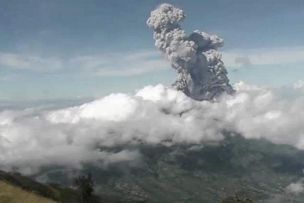 This handout photo taken and released on June 21, 2020 by Indonesia's Research and Technology Development for Geological Hazard Mitigation (BPPTKG) shows the Merapi Mount volcano spewing thick smoke into the air as seen from Yogyakarta. AFP PHOTO / BPPTKG
