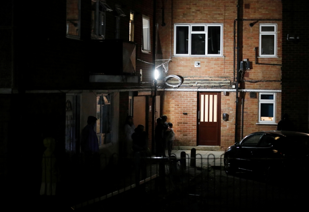 Residents outside a block of flats where suspect was earlier apprehended following reported multiple stabbings in Reading, Britain, June 20, 2020. REUTERS/Peter Cziborra