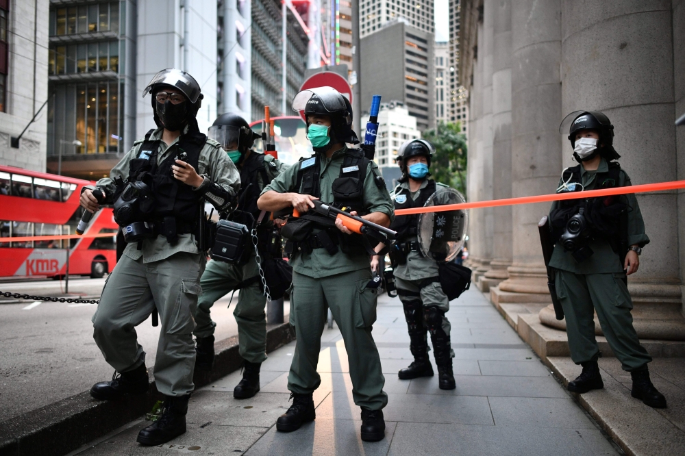 In this file photo riot police officers stand guard ahead of a pro-democracy march in the Central district of Hong Kong on June 9, 2020. AFP / Anthony Wallace 