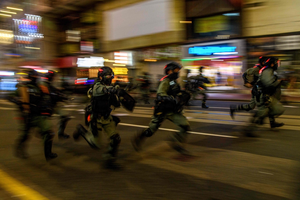 TOPSHOT - Police charge towards protesters during a rally against a new national security law in Hong Kong on July 1, 2020, on the 23rd anniversary of the city's handover from Britain to China./ AFP / Anthony WALLACE
 
