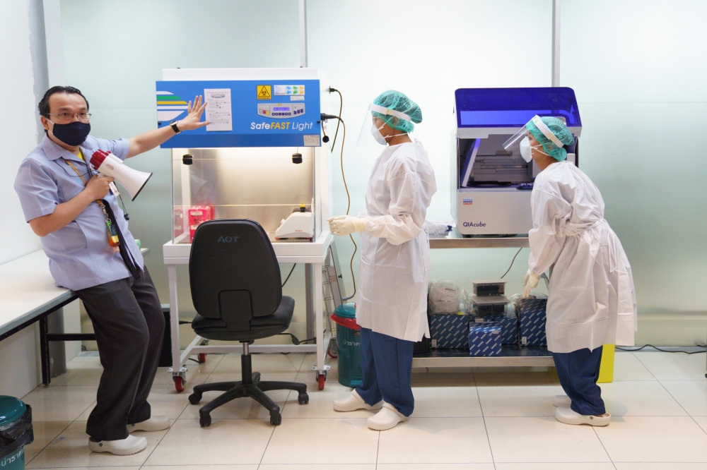 A doctor and medical staffs wearing personnel protective equipment (PPE) demonstrate the lab workflow at the COVID-19 testing laboratory at Bangkok's Suvarnabhumi International airport amid the spread of the coronavirus disease (COVID-19), Thailand, June 