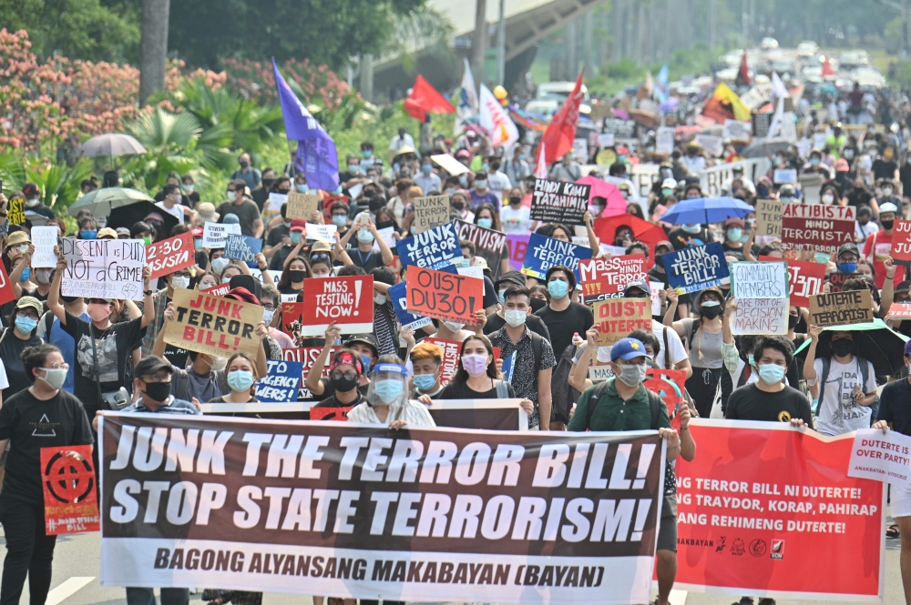 This file photo was taken on June 4, 2020, shows mask-clad protesters marching against an anti-terrorism bill at a university campus in Manila. / AFP / Ted ALJIBE
