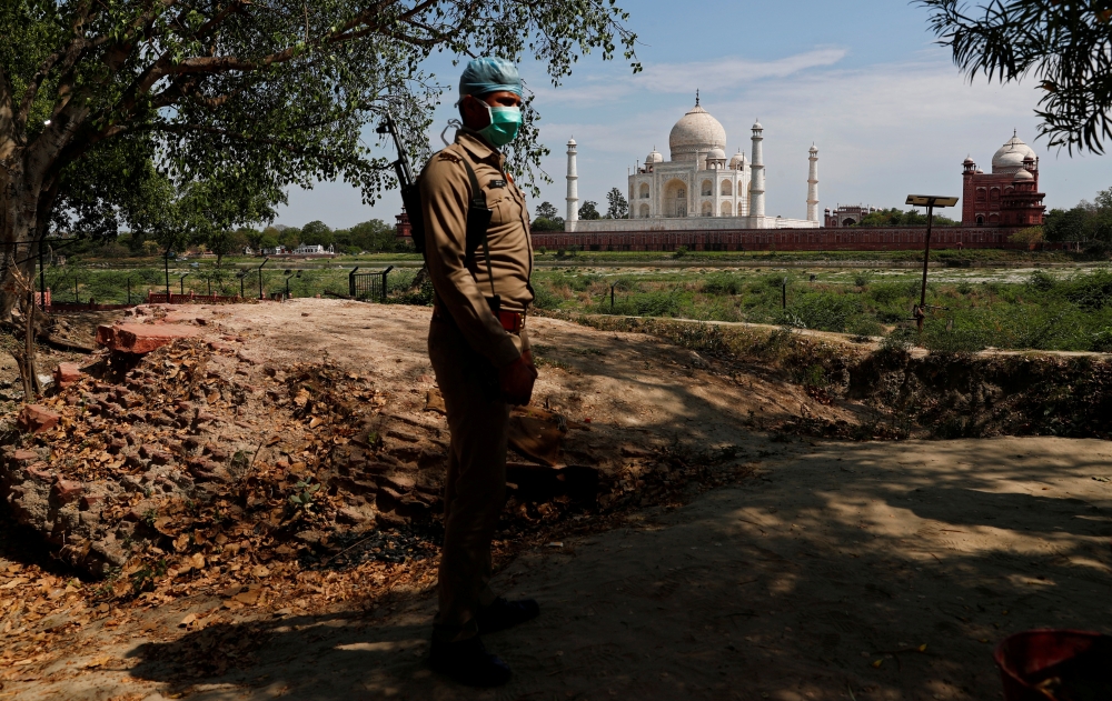A policeman wearing a protective mask stands guard near the historic Taj Mahal during a nationwide lockdown to slow the spread of COVID-19, in Agra, India, April 23, 2020. Picture taken April 23, 2020. REUTERS/Adnan Abidi/File Photo
