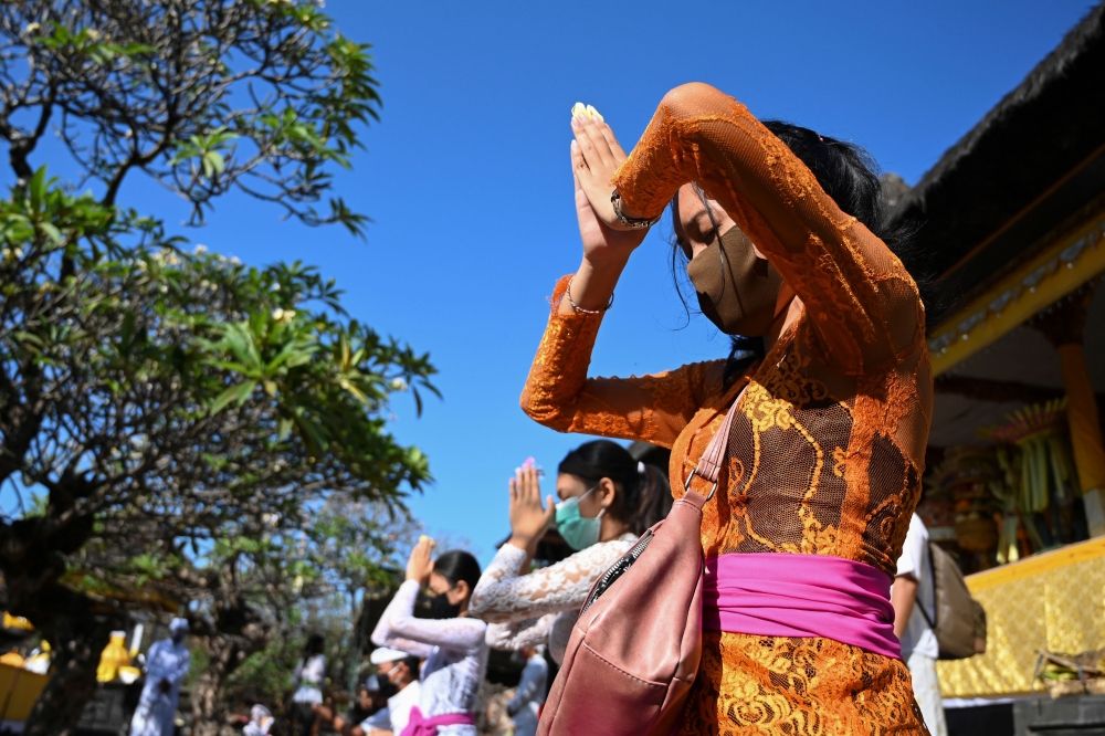 People pray during a ceremony dedicated to the Hindu deity Saraswati at Jagatnatha temple in Denpasar on the Indonesian resort island of Bali on July 4, 2020. / AFP / SONNY TUMBELAKA
